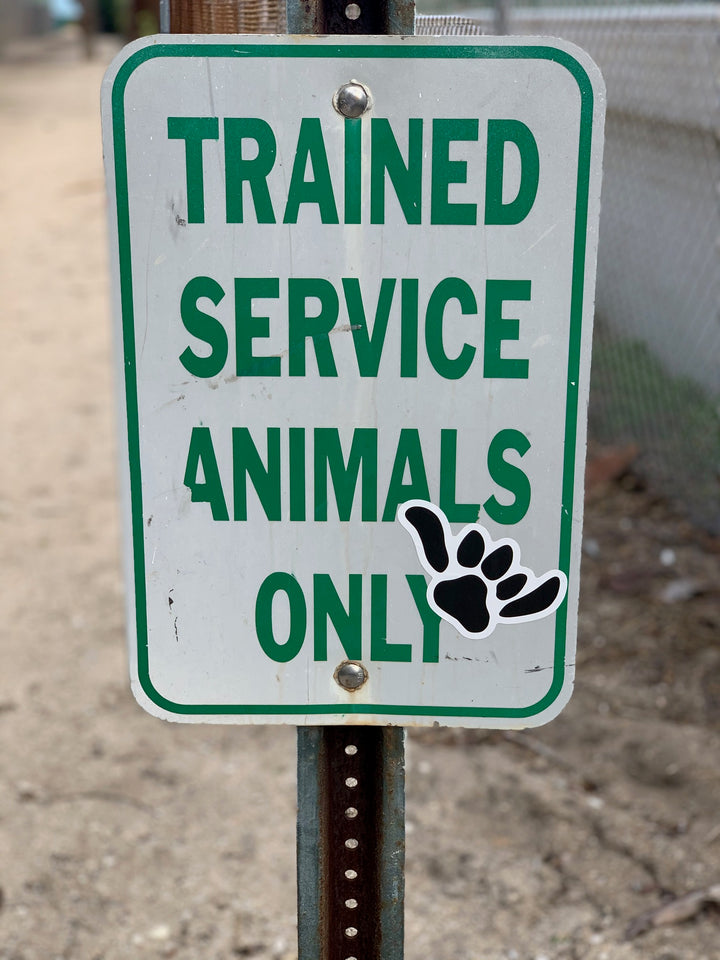 Salty Paws Shaka Paw sticker on street sign — South Florida surf dog brand sticker